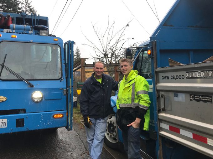 Two SSC employees standing near garbage pickup truck